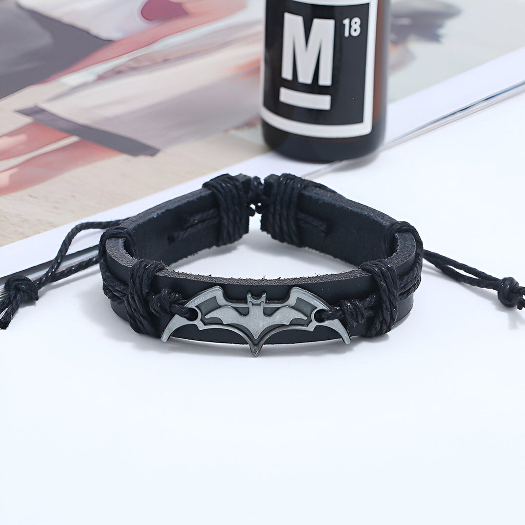 Bracelet en cuir noir pour homme avec logo Batman en métal gris, style tressé et fermeture réglable.
