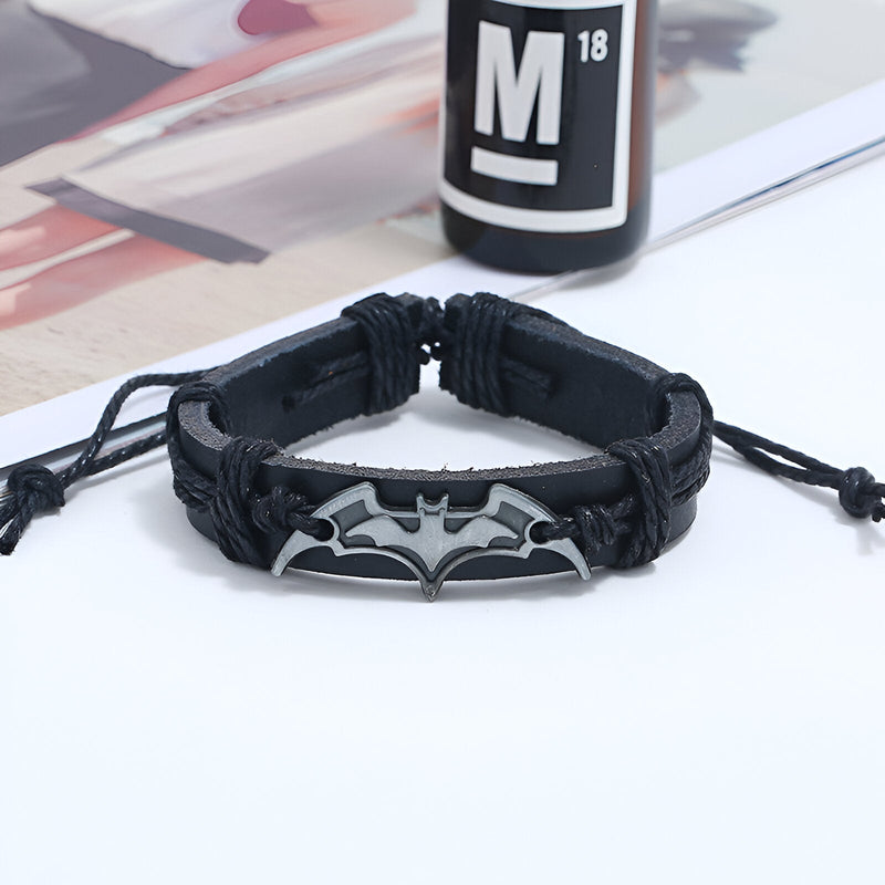 Bracelet en cuir noir pour homme avec logo Batman en métal gris, style tressé et fermeture réglable.