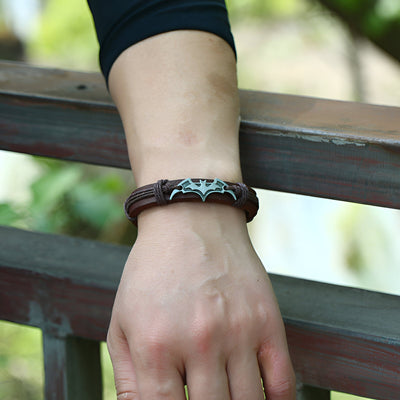 Bracelet en cuir marron avec logo Batman argenté, style masculin et robuste.