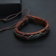 Bracelet en cuir marron avec logo Batman en métal noir, style homme ajustable.