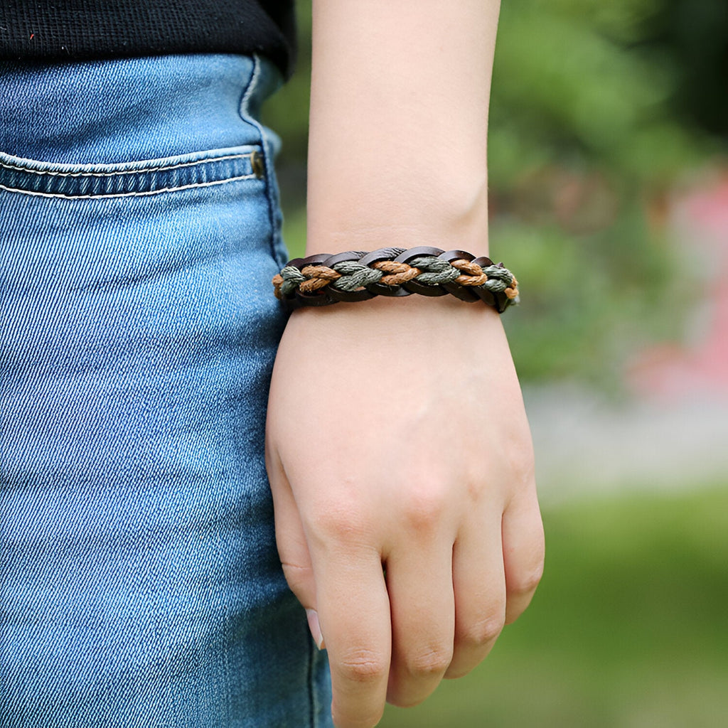 Bracelet en cuir marron tressé et torsadé, style unisexe, porté au poignet.