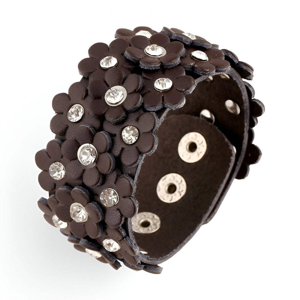 Bracelet manchette en cuir café orné de fleurs en relief avec strass brillants et fermeture à boutons-pression.