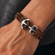 Bracelet marin en cuir tressé marron avec ancre en acier inoxydable argenté, fermeture boucle robuste.