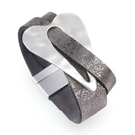 Bracelet femme en cuir microfibre noir avec grand cœur central argenté et fermoir métallique élégant.