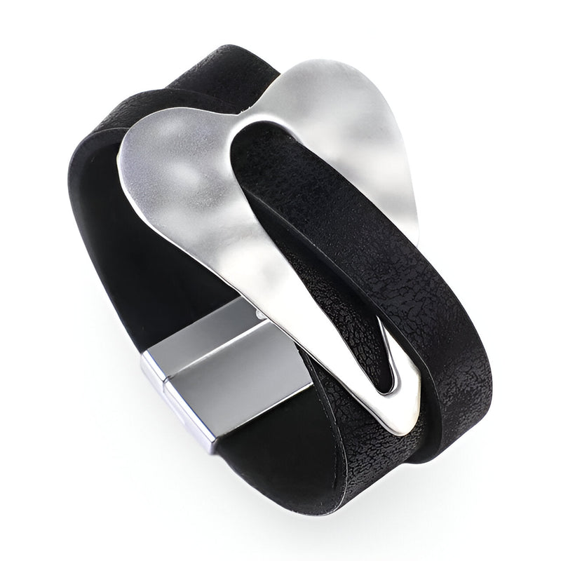 Bracelet en cuir noir avec grand cœur central en métal argenté et fermoir magnétique.