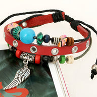 Bracelet cuir rouge avec œillets métalliques, perles multicolores et pendentif aile argentée.