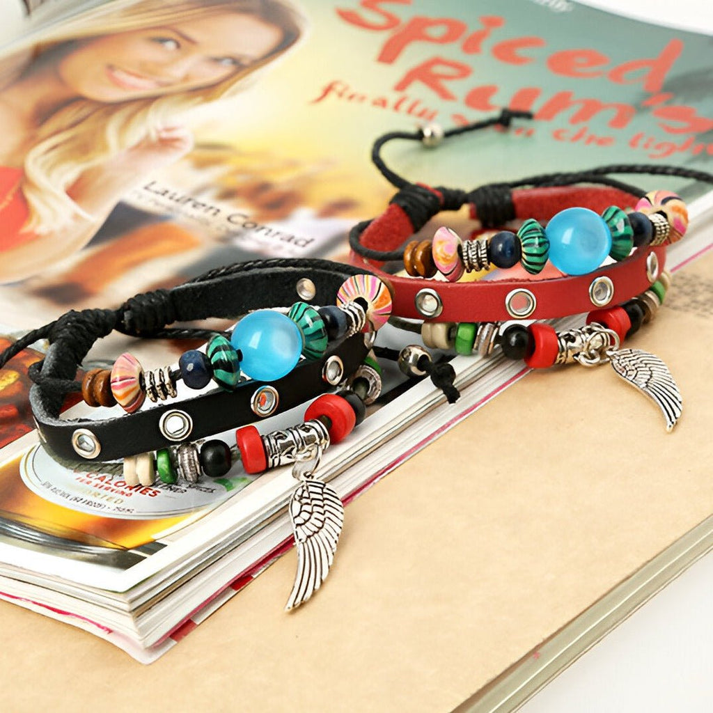 Bracelet en cuir noir et rouge avec perles colorées, détails métalliques et pendentif aile argenté.