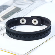 Bracelet en cuir noir avec motif de cœurs embossés et fermoir à pression métallique.
