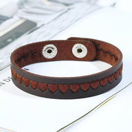Bracelet en cuir marron avec motif de petits cœurs embossés et fermeture à pression métallique argentée.