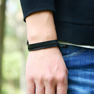 Bracelet en cuir noir avec motif de cœurs embossés, fermeture métallique, style mixte.