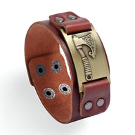 Bracelet en cuir café avec plaque en métal doré ornée d'un motif hache avec détails gravés.