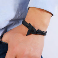 Bracelet noir en cuir avec motif queue de baleine, fermoir élégant, style masculin.