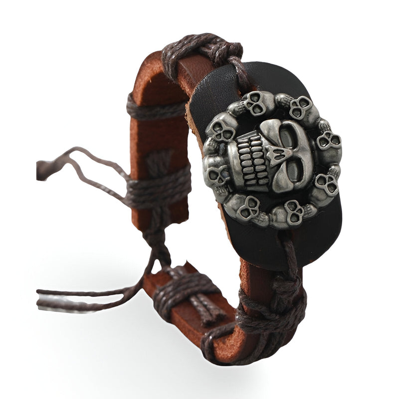 Bracelet en cuir marron avec tressage noir et large plaque noire ornée d'une tête de mort argentée encerclée de petites.