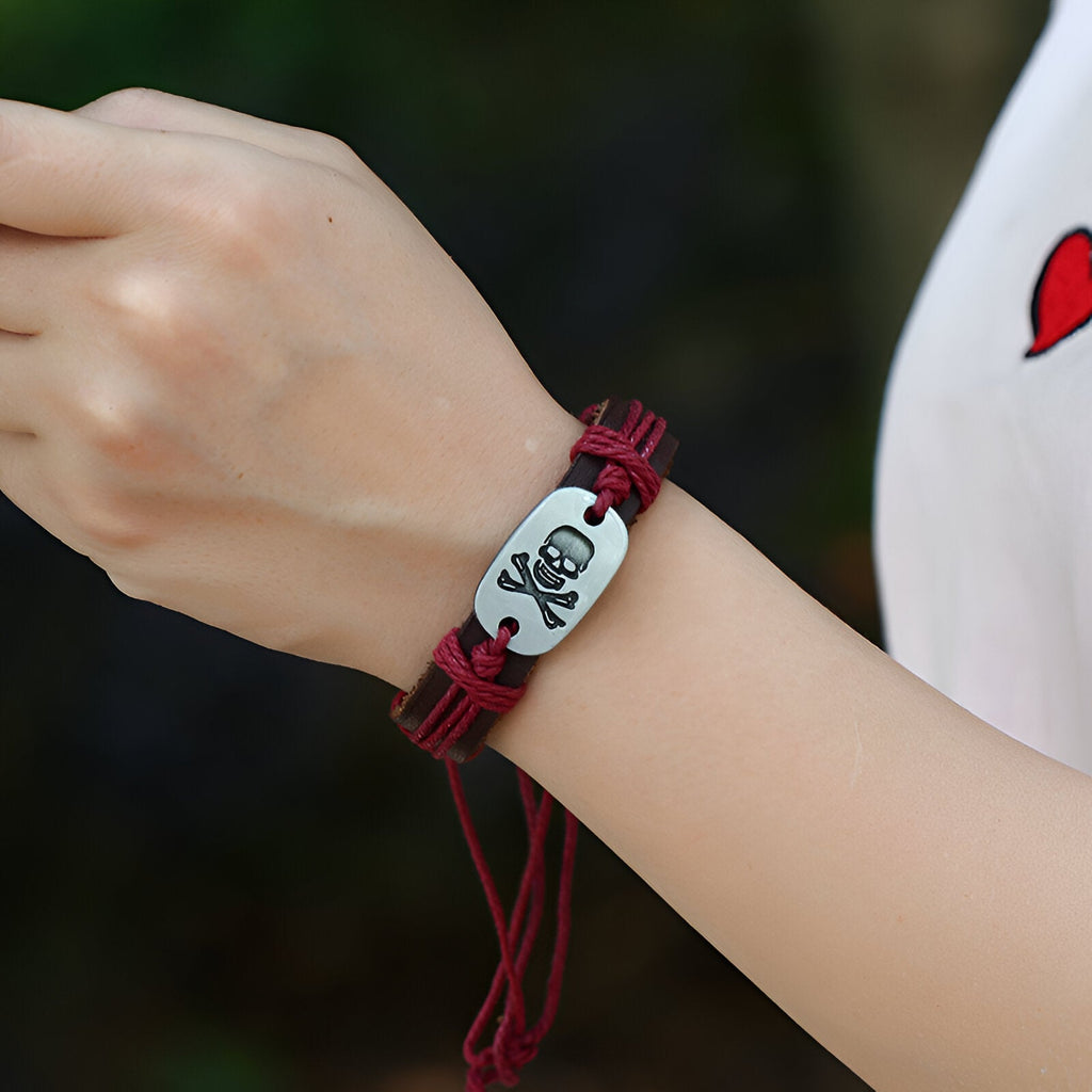 Bracelet en cuir rouge avec plaque centrale argentée décorée d'une tête de mort noire, style ajustable.
