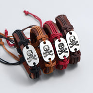 Bracelets en cuir tressé noir, marron clair, rouge et marron foncé avec plaque métal tête de mort gravée.