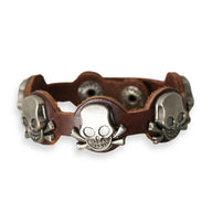 Bracelet en cuir marron avec trois têtes de mort en métal argenté, style homme rock.