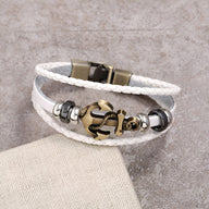 Bracelet multi-rangs en cuir blanc avec ancre marine bronze et perles métalliques grises.