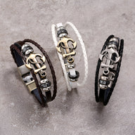 Bracelet multi-rangs en cuir marron avec ancre marine métallique dorée et détails argentés.