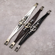 Bracelets en cuir multi-rangs avec ancre marine en métal, disponibles en blanc, marron et noir sur fond gris.
