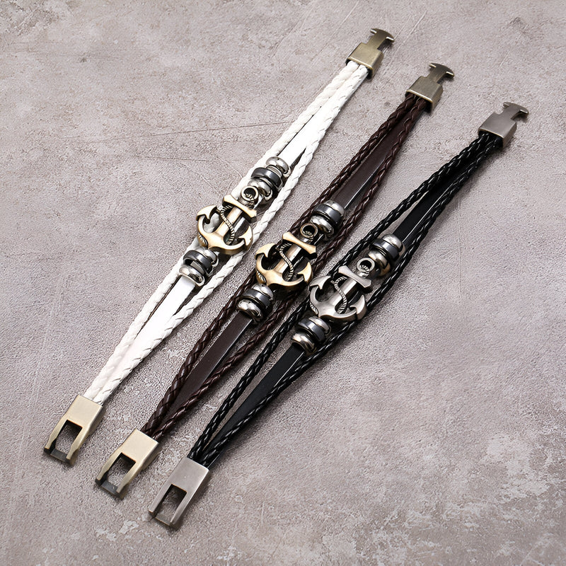 Bracelets en cuir multi-rangs avec ancre marine en métal, disponibles en blanc, marron et noir sur fond gris.