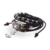 Bracelet multi-rangs en cuir marron avec perles en bois, métal argenté et charm ancre suspendu.