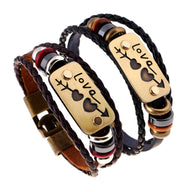 Bracelet en cuir noir multi-rangs avec plaque dorée gravée "Love" et symboles assortis.