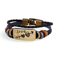 Bracelet en cuir noir multi-rangs avec plaque dorée gravée "Love" et motifs cœurs, fermoir métallique.