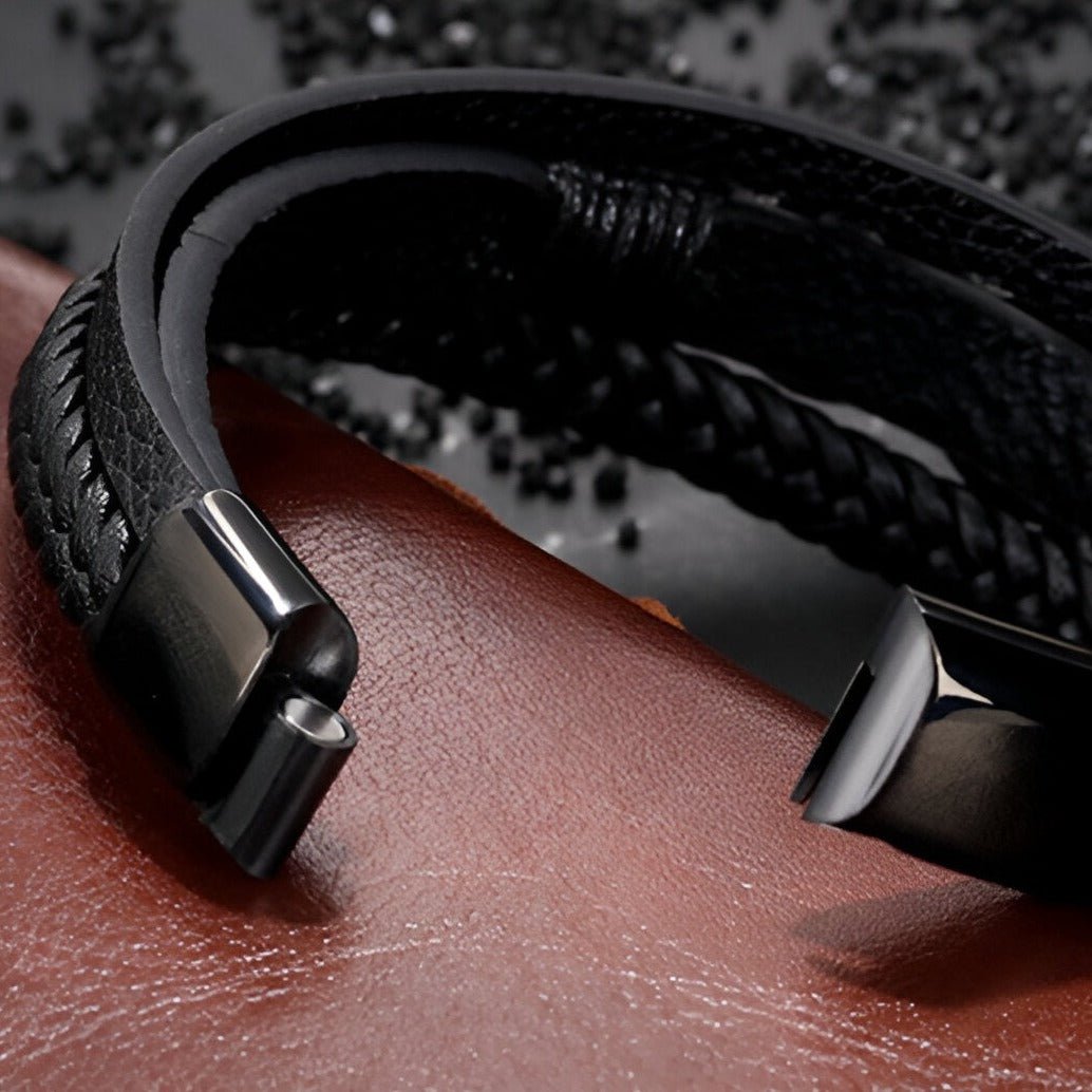 Bracelet multi-rangs en cuir noir avec motif infini et fermoir métallique noir mat.