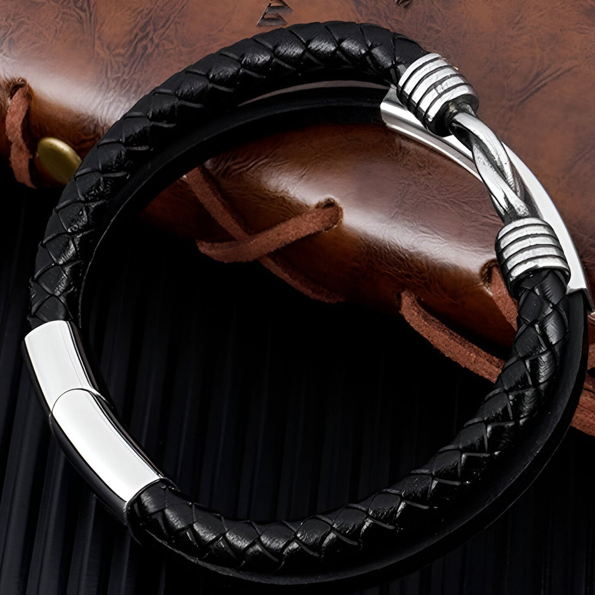 Bracelet multi-rangs en cuir noir tressé avec fermoir argenté texturé élégant.