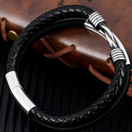 Bracelet multi-rangs en cuir noir tressé avec fermoir argenté texturé élégant.