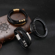 Bracelet multi-rangs en cuir noir avec fermoir doré, style tressé et détails métalliques argentés et noirs.