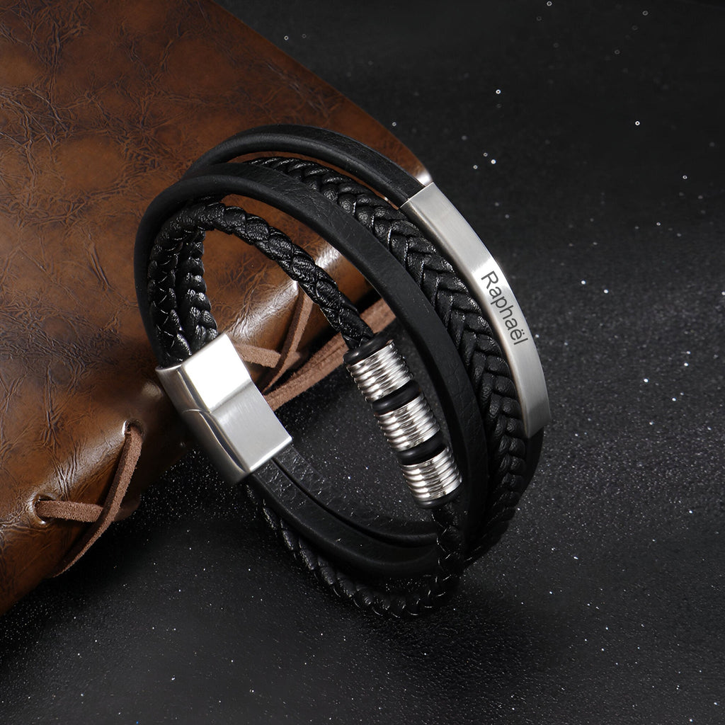 Bracelet multi-rangs en cuir noir tressé avec fermoir et détails argentés personnalisés.