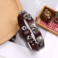 Bracelet en cuir marron avec plusieurs têtes de mort argentées, style masculin.