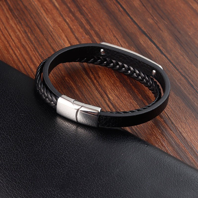 Bracelet homme en cuir noir tressé avec plaque acier gravée et fermoir magnétique argenté élégant.