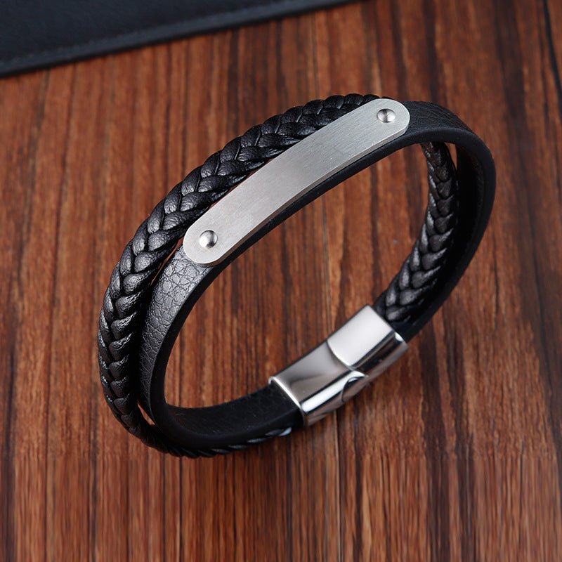 Bracelet en cuir noir tressé avec plaque acier gravée et fermoir magnétique argenté élégant.