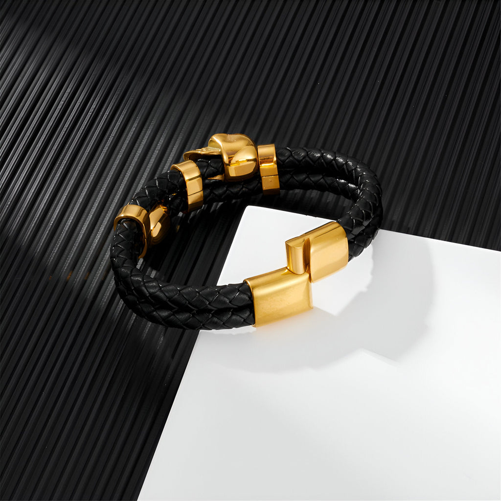 Bracelet en cuir noir tressé avec ornement tête de mort doré et fermoir magnétique doré.