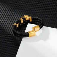 Bracelet en cuir noir tressé avec ornement tête de mort doré et fermoir magnétique doré.