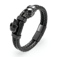 Bracelet en cuir noir tressé avec ornement double têtes de mort en métal noir mat.