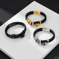 Trois bracelets en cuir noir tressé avec ornements double têtes de mort en argent, noir et or.