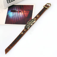 Bracelet en cuir marron avec symbole peace and love et oiseaux en métal doré, fermoir boucle dorée.