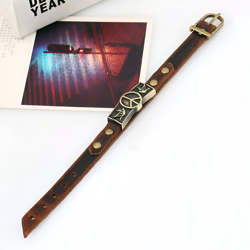 Bracelet en cuir marron avec symbole peace and love et oiseaux en métal doré, fermoir boucle dorée.