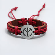 Bracelet en cuir rouge avec symbole paix métallique rond et cordons ajustables.