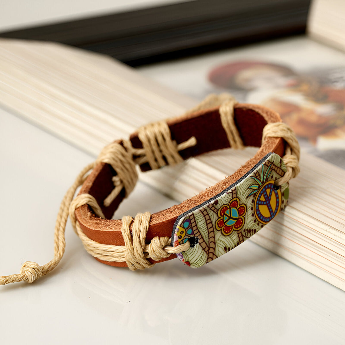 Bracelet pour homme en cuir marron avec plaque décorative Peace and Love colorée et cordons tressés beige.