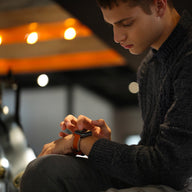 Bracelet en cuir marron à couture contrastée blanche avec boucle en acier pour Apple Watch, style moderne et masculin.