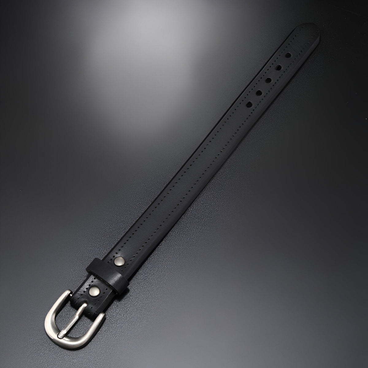 Bracelet noir en cuir avec boucle ardillon argentée et coutures ton sur ton.