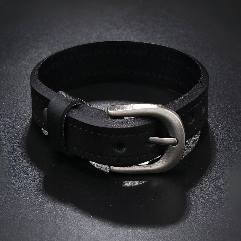 Bracelet en cuir noir pour homme avec boucle ardillon argentée et coutures apparentes.