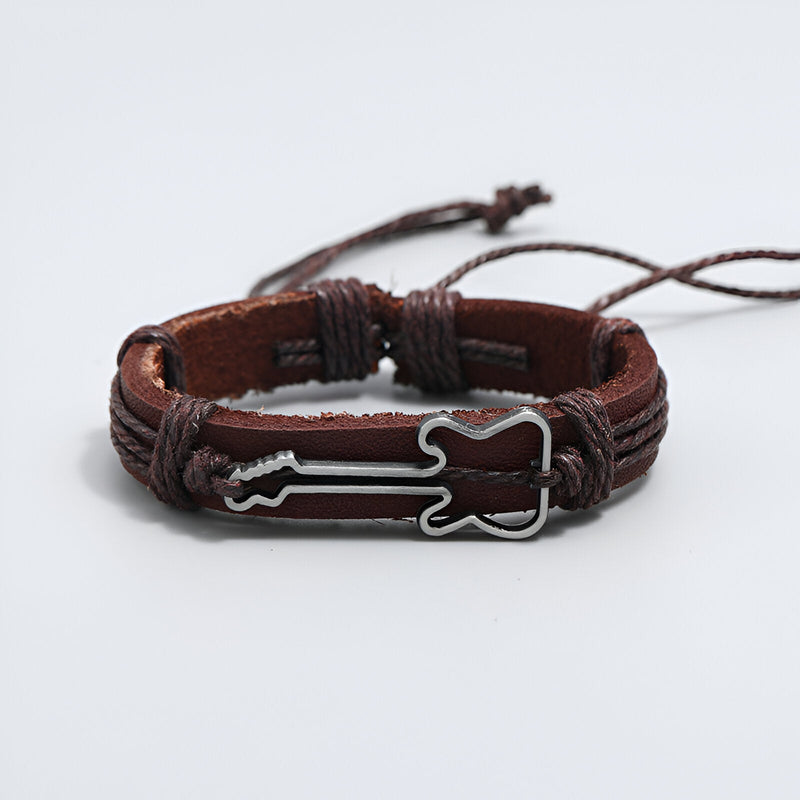 Bracelet en cuir marron avec cordons réglables et charm guitare en métal noir et argenté.