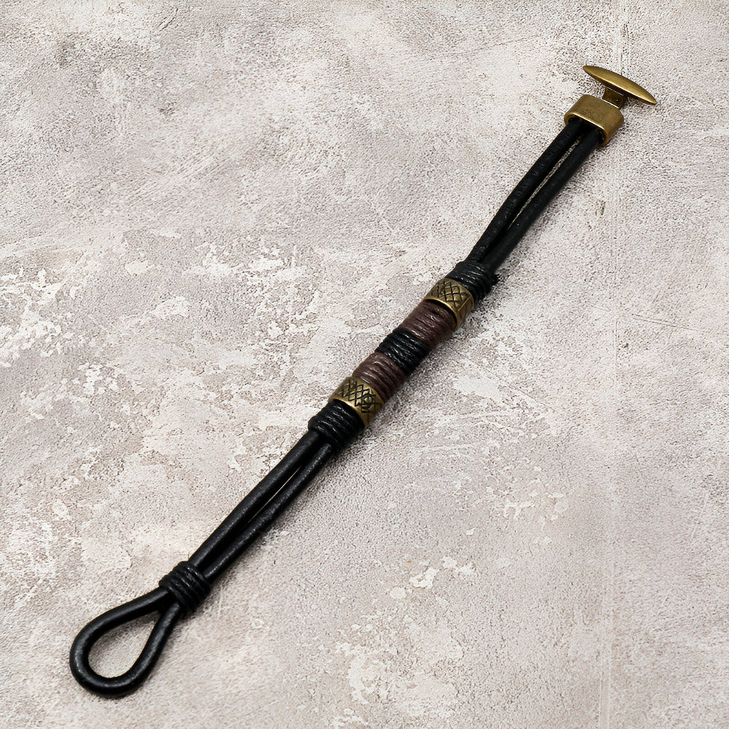 Bracelet homme en cuir noir avec éléments dorés et détails tressés style égyptien Horus.