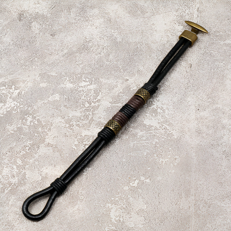 Bracelet homme en cuir noir avec éléments dorés et détails tressés style égyptien Horus.