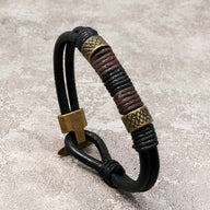 Bracelet homme en cuir noir avec détails en métal doré de style égyptien Horus.